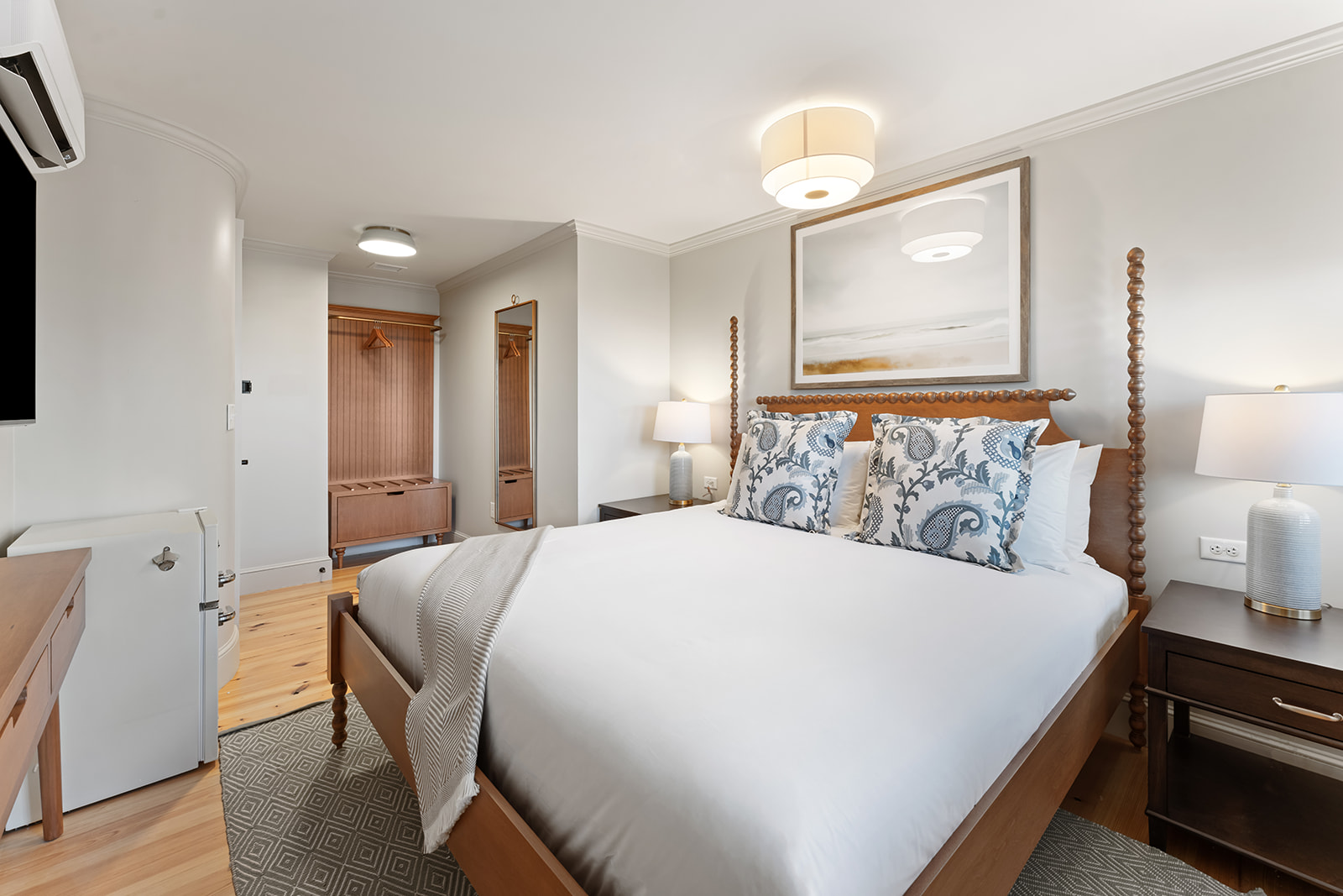 A clean and cozy hotel room with a large bed, wooden furniture, and minimal decor.