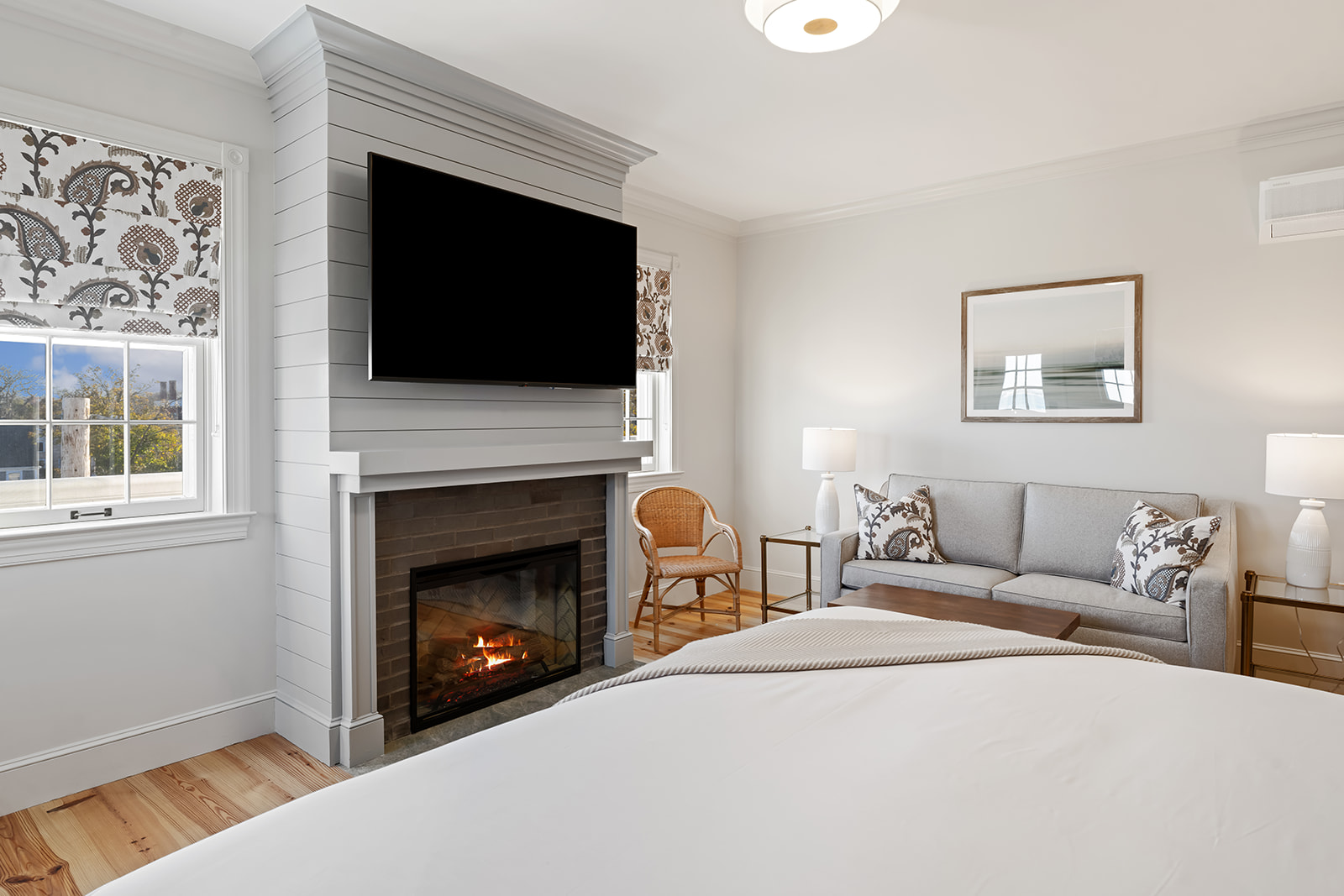 A cozy guest room with a fireplace, TV, sofa, and bed