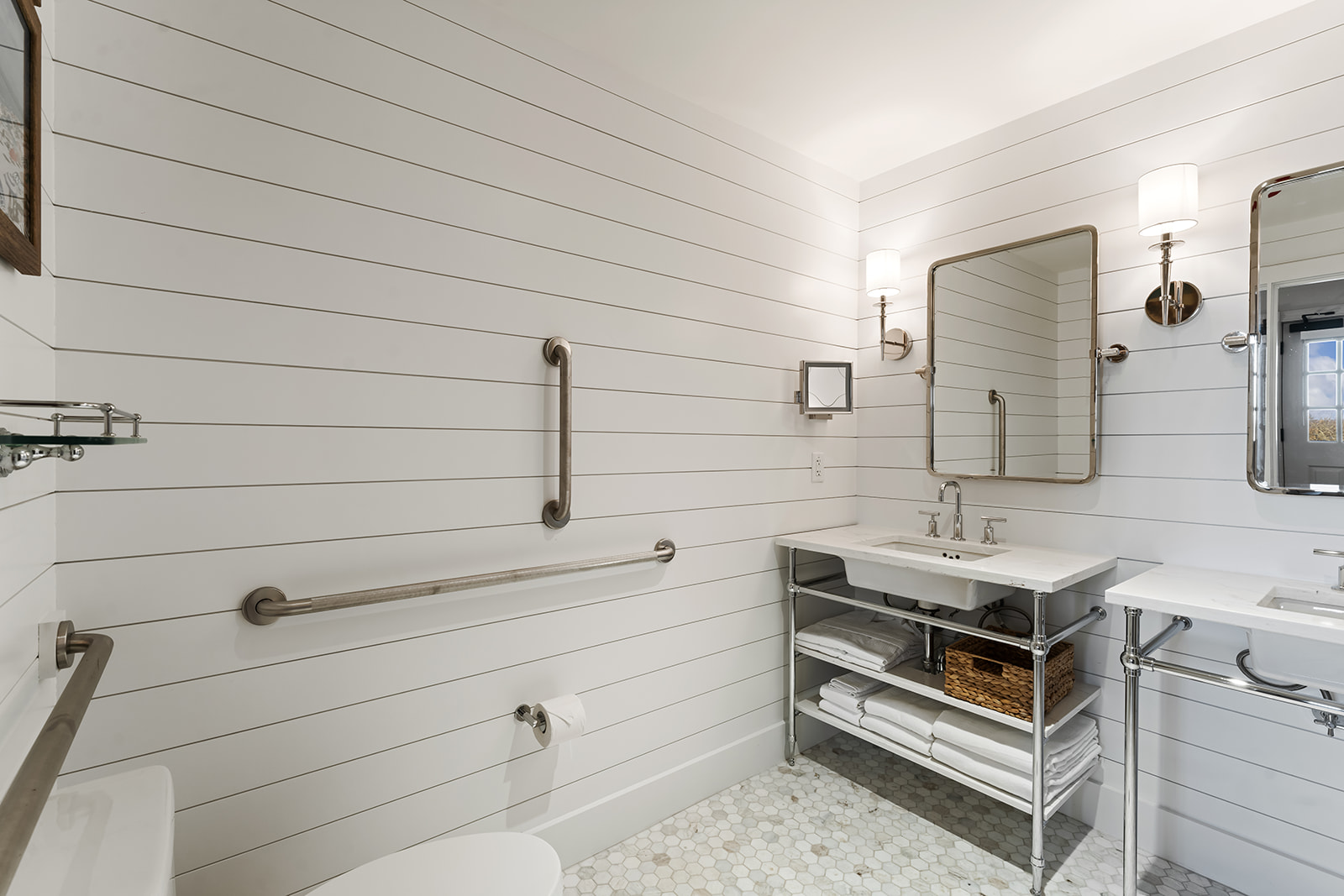 A clean and modern bathroom with shiplap walls, a double vanity, and a toilet.